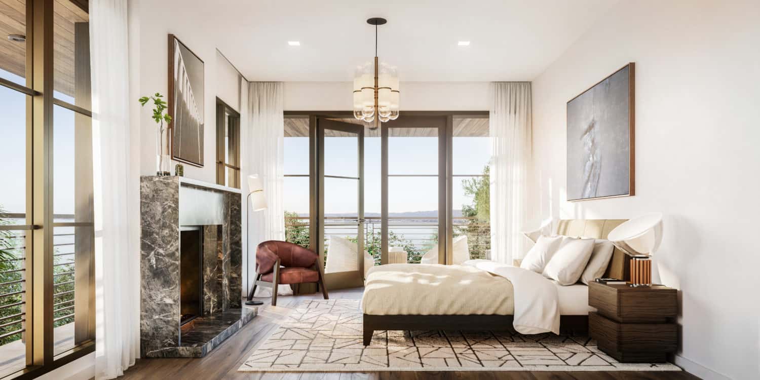 Master bedroom at The Townhomes in San Francisco. Large open room with grand windows, a fireplace and wrap around deck.